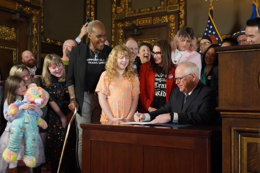 Le gouverneur démocrate du Minnesota, Tim Walz, signant un décret garantissant la protection des mineur·es trans venu·es bénéficier de soins d’affirmation de genre dans son État.