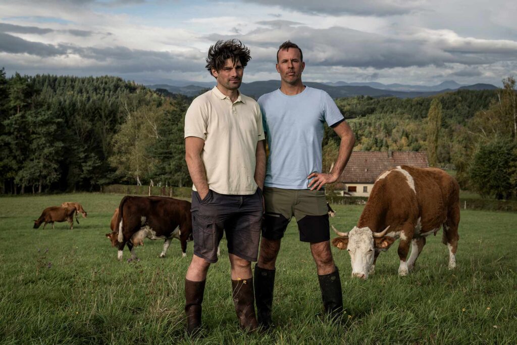 Patrice (à gauche), et François, en couple depuis dix-sept ans et mariés depuis trois ans, sont à la tête d’une exploitation bio de 60 vaches laitières à Auzelles (Puy-de-Dôme). Le premier est fils d’agriculteur·ices et s’est installé à proximité de la ferme parentale. Le second, ingénieur de formation, a grandi en ville. C’est leur amour pour les bovins et la nature qui les a réunis et leur a permis de surmonter de multiples obstacles. D’abord la dureté du métier, « un mode de vie qui te coupe de ton réseau social », où « tu côtoies la vie, la mort, tous les jours », mais aussi le regard porté sur eux : « Quand tu es gay et que, en plus, l’un des deux n’est pas du milieu, tu n’as jamais fini de faire tes preuves », relève François. Leur différence, c’est leur « sensibilité » : « On travaille avec les animaux, pas contre. »