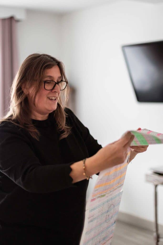 Daisy Audouze en train de lire son planning de 
la semaine. L’accueil de plusieurs enfants (jusqu’à quatre) oblige souvent les assistantes maternelles 
à dépasser les 45 heures hebdomadaires. Crédit : Elsa Biyick pour La Déferlante.