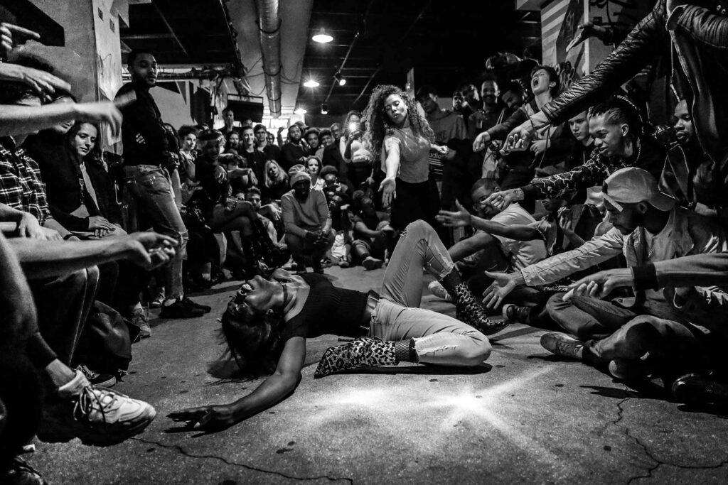 Au ball La Récré, à L’Alimentation générale à Paris, en avril 2018. Keiona, mother de la House of Revlon, est sur le point de réaliser un dip. Cette figure emblématique du voguing consiste
à tomber au sol sur le dos, une jambe repliée et l’autre tendue en l’air.
Photo publiée dans le portfolio
de La Déferlante no 10, mai 2023.
Teresa Suárez